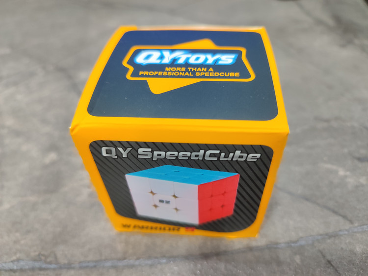 روبیک مکعبی برند QYTOYS با برچسبهای رنگی استاندارد، بدنه مشکی براق و مکانیزم چرخش روا